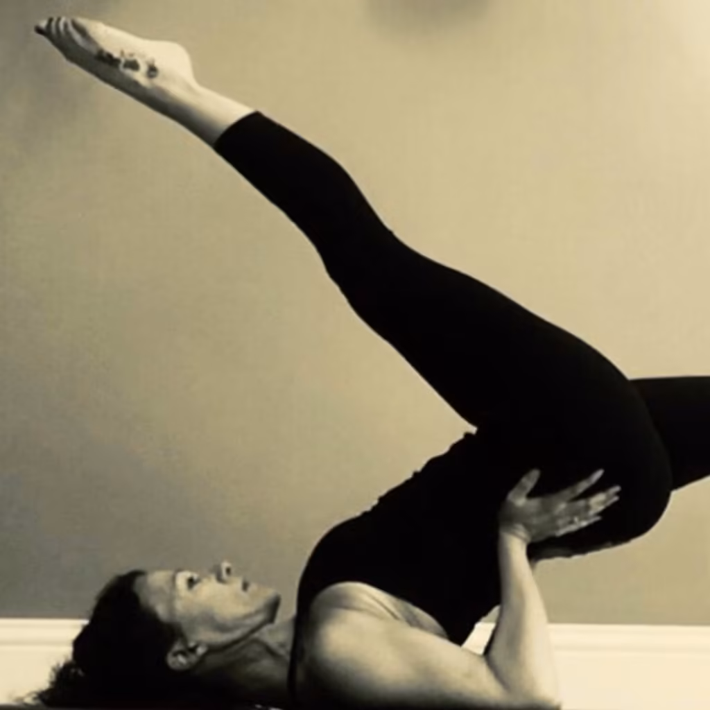 A Mat Pilates student in a shoulder bridge